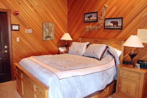 a bedroom with a bed with wooden walls and two lamps at The Inn at Dresden in Dresden