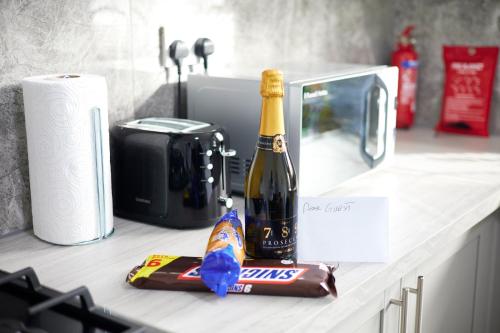 a bottle of champagne and a bag of chips on a counter at The Ol-Mumps Cozy Corner in Oldham