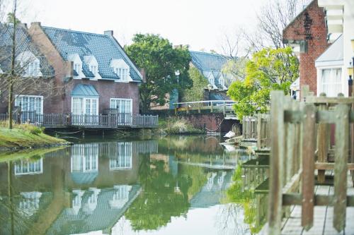 a river with houses and a bridge in a town at Forest Villa Huis Ten Bosch in Sasebo