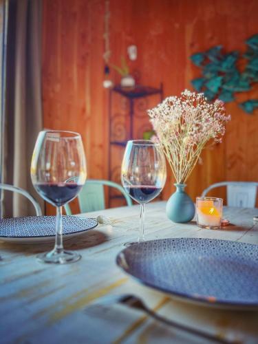 2 verres à vin assis sur une table en bois dans l'établissement La Cabanarêve Plage Spa pour 6 personnes, à Lanton