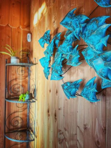 Une bande de parasols bleus suspendus sur un mur dans l'établissement La Cabanarêve Plage Spa pour 6 personnes, à Lanton