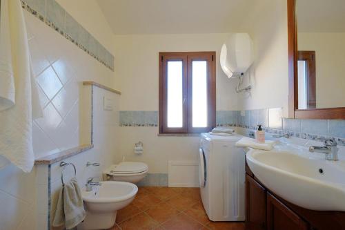 um banheiro com uma pia, um vaso sanitário e uma janela em Il giardino di Marina em Teulada