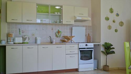 a kitchen with white cabinets and a stove top oven at Апартамент Деа - Apartment Dea in Byala