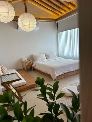 a bedroom with a bed and a couch and a table at Yeomok Stay in Gyeongju