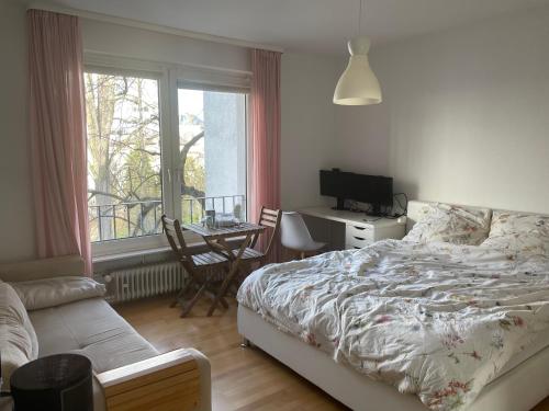 a bedroom with a bed and a desk and a window at Feel home Room in Frankfurt/Main