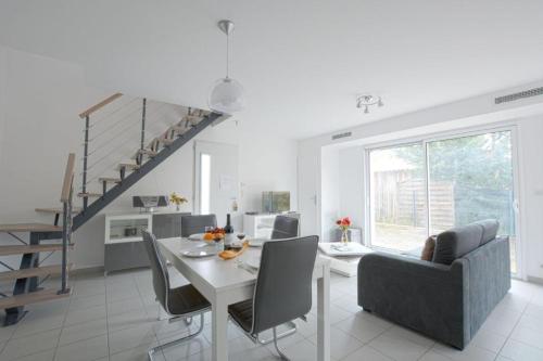 une cuisine et une salle à manger avec une table et des chaises dans l'établissement Les Fougères maison tout confort 4 personnes, à Andernos-les-Bains