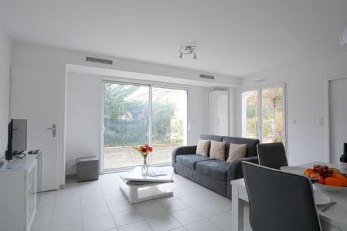 un salon avec un canapé et une table dans l'établissement Les Fougères maison tout confort 4 personnes, à Andernos-les-Bains