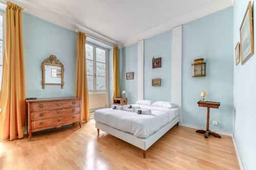- une chambre avec un grand lit blanc et une commode dans l'établissement GuestReady - Elegant Getaway in Central Lyon, à Lyon