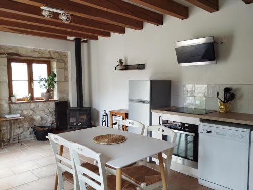 une cuisine avec une table et des chaises dans une pièce dans l'établissement Jolie maison au calme, à Châteauvieux