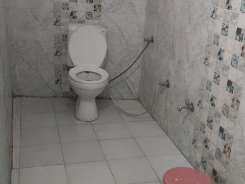 uma casa de banho com WC num quarto em azulejo em Shree Mahakaal Inn by StayApart em Gupta Kāshi