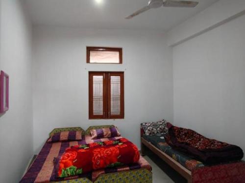 um quarto com uma cama, um sofá e uma janela em Shree Mahakaal Inn by StayApart em Gupta Kāshi