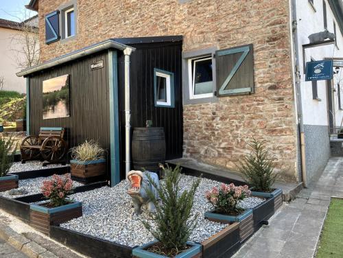 a garden with potted plants in front of a house at Happy Hippo Haus in Mürlenbach