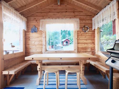 a dining room with a wooden table and two chairs at Cozy 4BR Lakeside Cottage with Sauna & Outdoor Grill in Lahti
