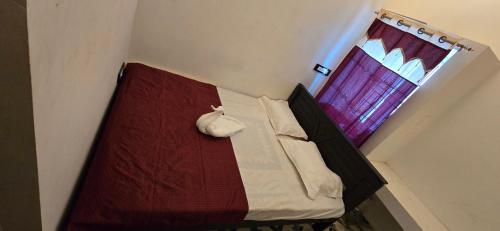 a small bedroom with a bed with a window at KK Dream Garden in Kāraikkudi