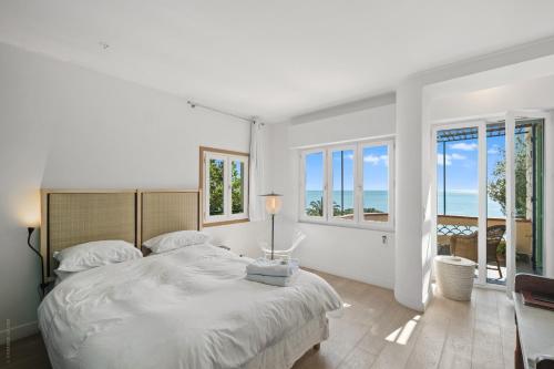 - une chambre blanche avec un grand lit et des fenêtres dans l'établissement Exclusive!Villa Eolienne:Vue Mer,Piscine, à Nice