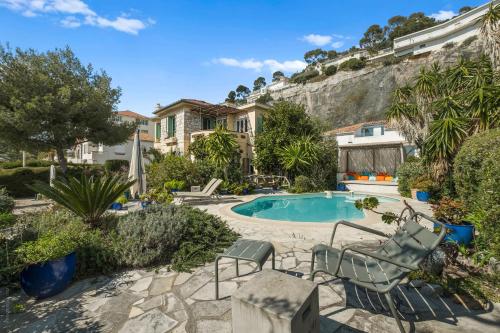une maison avec une piscine et deux chaises longues dans l'établissement Exclusive!Villa Eolienne:Vue Mer,Piscine, à Nice