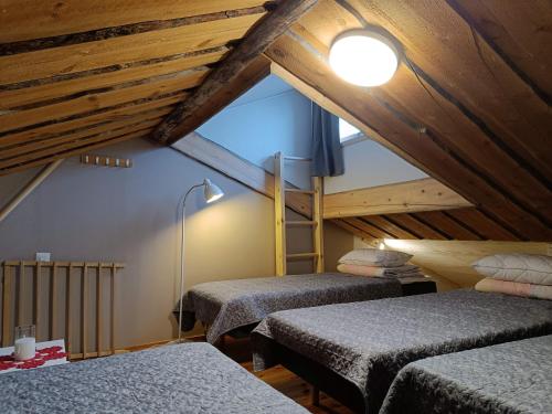 Una habitación abuhardillada con dos camas individuales y una escalera. en Huipuntupa A6, en Syöte