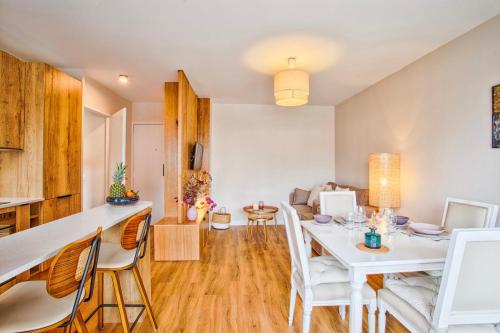 une salle à manger et un salon avec une table et des chaises blanches dans l'établissement Le Morny Palace - 2P - Place Morny - DEAUVILLE, à Deauville