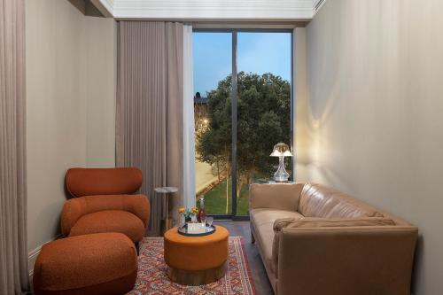 a living room with a couch and a chair and a window at Komana Hotel Binbirdirek in Istanbul