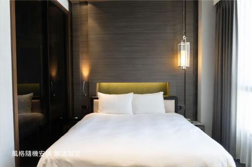a bedroom with a large white bed in it at Boda Hotel in Taichung
