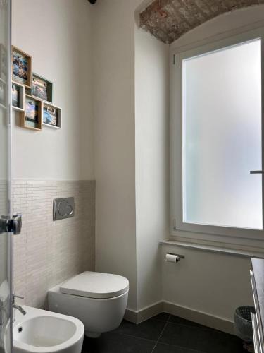 a bathroom with a toilet and a sink and a window at Vibes 5terre in Riomaggiore