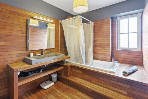 une salle de bain avec une baignoire, un lavabo et un miroir dans l'établissement La Trentemousine - Familiale & Chaleureuse, à Rezé