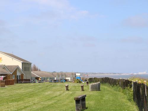 a yard with a house and a field of grass at No 108 Waterside in Lowestoft