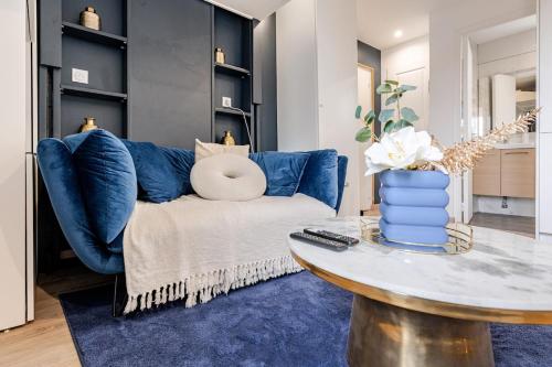 un salon avec un canapé bleu et une table dans l'établissement Le Bertin- cosy appartement Montfermeil, à Montfermeil