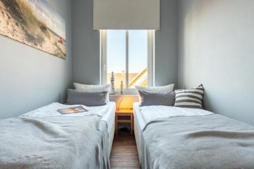 two beds in a room with a window at Rodehuus Wohnung 9 in Borkum
