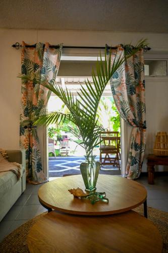 a living room with a table with a plant on it at Villa Corail - Premier repas offert sur place in Cap Malheureux