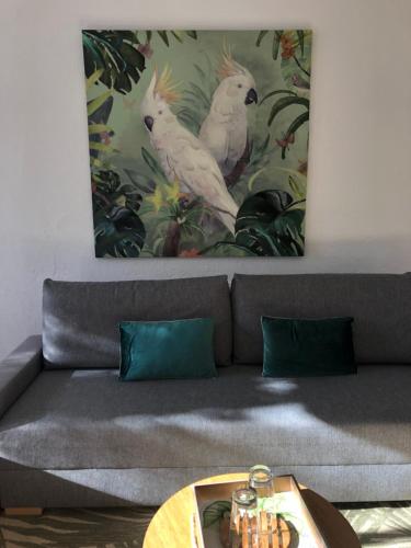a living room with a couch with a painting on the wall at Casa Mallarenga Rooms in Olivella