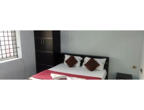 a bedroom with a bed with brown pillows at Hotel Annamalai, Rameswaram in Rāmeswaram
