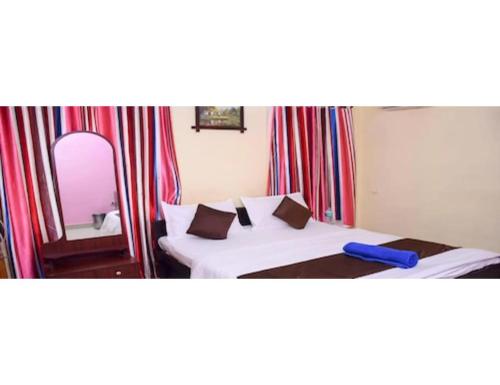 a hotel room with two beds and a mirror at Hotel Annamalai, Rameswaram in Rāmeswaram