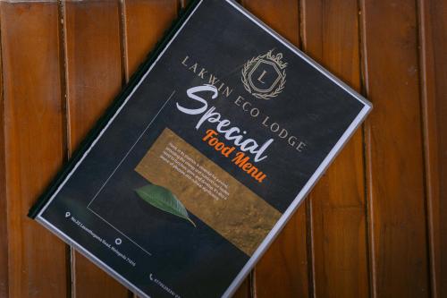 a book is hanging on a wooden wall at Lakwin Eco Lodge in Kegalle
