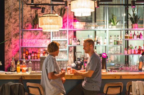 two men standing at a bar in a restaurant at Urban Nature St Peter-Ording in Sankt Peter-Ording