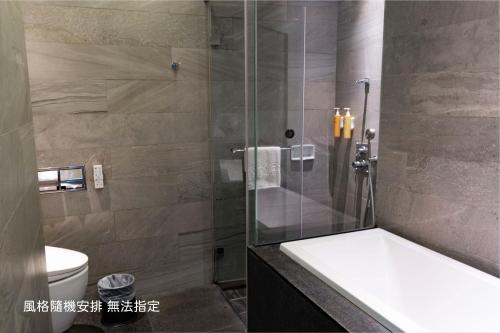 a bathroom with a shower with a tub and a toilet at Boda Hotel in Taichung