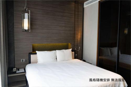 a bedroom with a large white bed in a room at Boda Hotel in Taichung