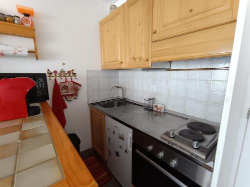 une petite cuisine avec un évier et une cuisinière dans l'établissement Studio rénové 2* avec coin montagne, 4-5 pers, proche pistes et commerces, village Montgenèvre - FR-1-445-32, à Montgenèvre
