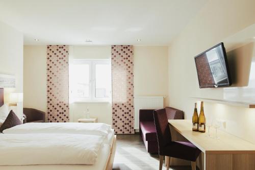 ein Hotelzimmer mit einem Bett und einem Schreibtisch in der Unterkunft Meyerhof - Weingut, Vinothek & Gästehaus in Flonheim