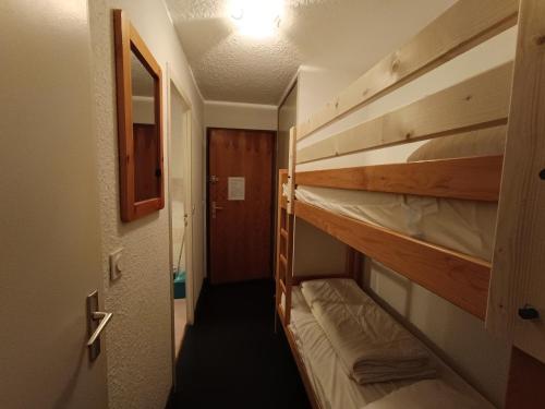 Cette chambre comprend 2 lits superposés dans un couloir. dans l'établissement Studio + Coin Montagne - 2* - 4 Pers. - Village - Terrasse Privée - Animaux Acceptés - FR-1-445-25, à Montgenèvre