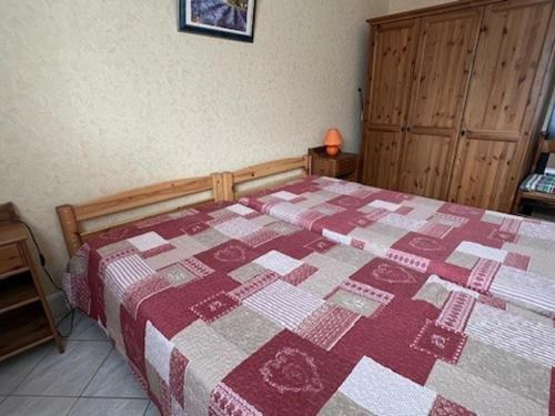 - une chambre avec un lit doté d'une couette rouge et blanche dans l'établissement Charmant T2 en RDC avec Jardin, Quartier Calme à Aix-les-Bains - FR-1-555-41, à Aix-les-Bains