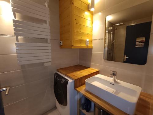 une salle de bain avec un lavabo et une machine à laver dans l'établissement Superbe appart rénové au sud - Parking - Montgenèvre - FR-1-445-156, à Montgenèvre