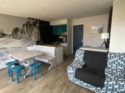 une pièce avec une table et des chaises et une cuisine dans l'établissement Superbe appart rénové au sud - Parking - Montgenèvre - FR-1-445-156, à Montgenèvre