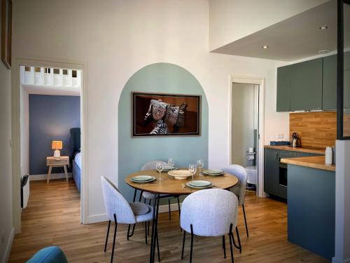 une cuisine et une salle à manger avec une table et des chaises dans l'établissement Appartement cœur de ville Arcachon, à Arcachon