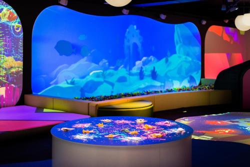 a video game room with a large screen at Zaliakalnio terasos apartamentai in Kaunas