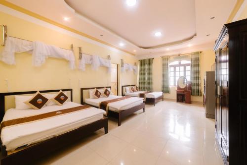 a hotel room with two beds and a television at Đoàn An điều dưỡng 198 in Khu Chi Lăng