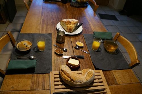 Una mesa con un plato de comida y vasos de jugo de naranja. en La Grange de Noëlie, en Lanuéjouls-et-Privezac