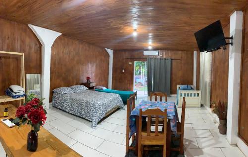 a bedroom with a bed and a table in a room at Hospedaje Terra Bela in Puerto Iguazú