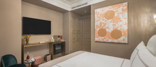 a hotel room with a bed and a flat screen tv at Komana Hotel Binbirdirek in Istanbul