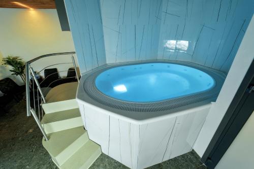 a jacuzzi tub in a building with stairs at Zaliakalnio terasos apartamentai in Kaunas